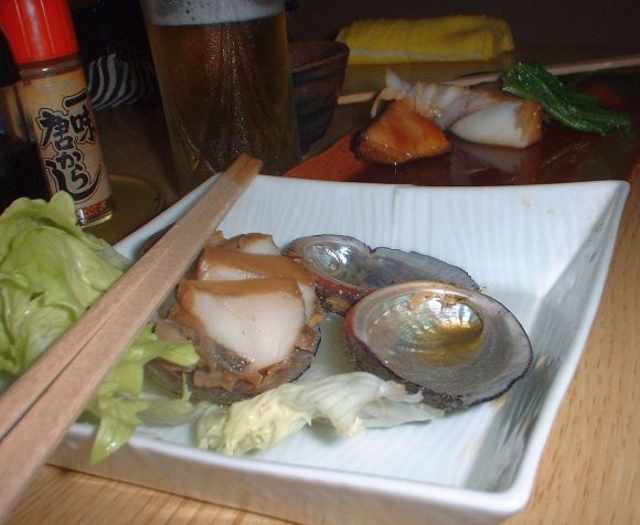 Sashimi di abalone dalla cucina asiatica di cibi crudi. Haliotis japonica sul piatto bianco.