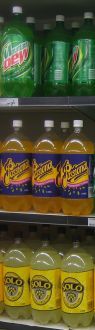 Estante de recorte en la tienda minorista con refrescos en botellas y latas. Estante de recorte en la tienda minorista con refrescos en botellas y latas.