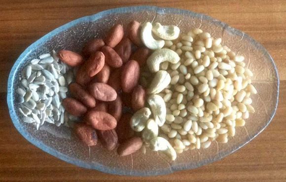 Фото: семена подсолнечника, сырые какао-бобы, орехи пеканы, кедровые орехи и кедровые семечки.