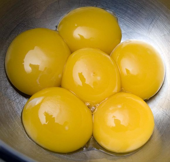 6 желтков (яичные желтки) в кастрюле, не приготовленные или жареные.