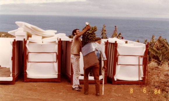 Mitarbeiter nimmt einem Träger einen Bananen-Arm vom Rücken und verladet zwischen Isoliermatten. Mitarbeiter nimmt einem Träger einen Bananen-Arm vom Rücken und verladet zwischen Isoliermatten.