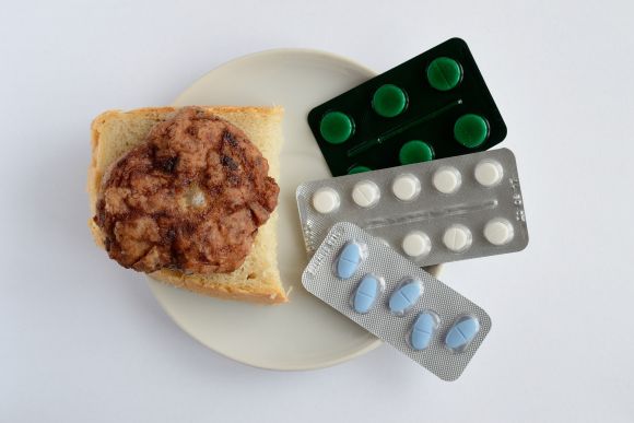 Вредный выбор: тарелка с куском хлеба и котлетой и всевозможные пищевые добавки. Вредный выбор: тарелка с куском хлеба и котлетой и всевозможные пищевые добавки.