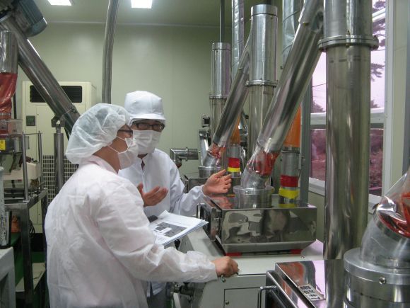 Due persone nella sala di lavorazione degli alimenti: il cibo trasformato è polvere di peperoncino. Due persone nella sala di lavorazione degli alimenti: il cibo trasformato è polvere di peperoncino.