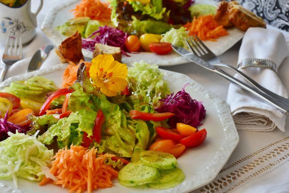 Красочная тарелка с сырой пищей - овощным салатом, который приглашает вас насладиться вкусной едой.