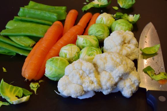 Vorbereitete Gemüse wie Karotten, Blumenkohl, Rosenkohl für die Zubereitung eines veganen Essens.