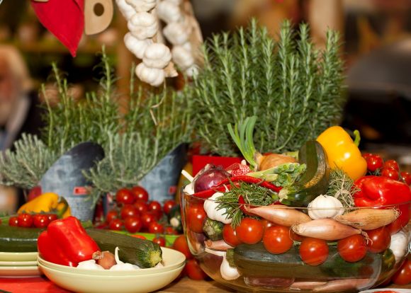 Many colorful vegetables in different containers on table. Vegan food incl. Herbs.