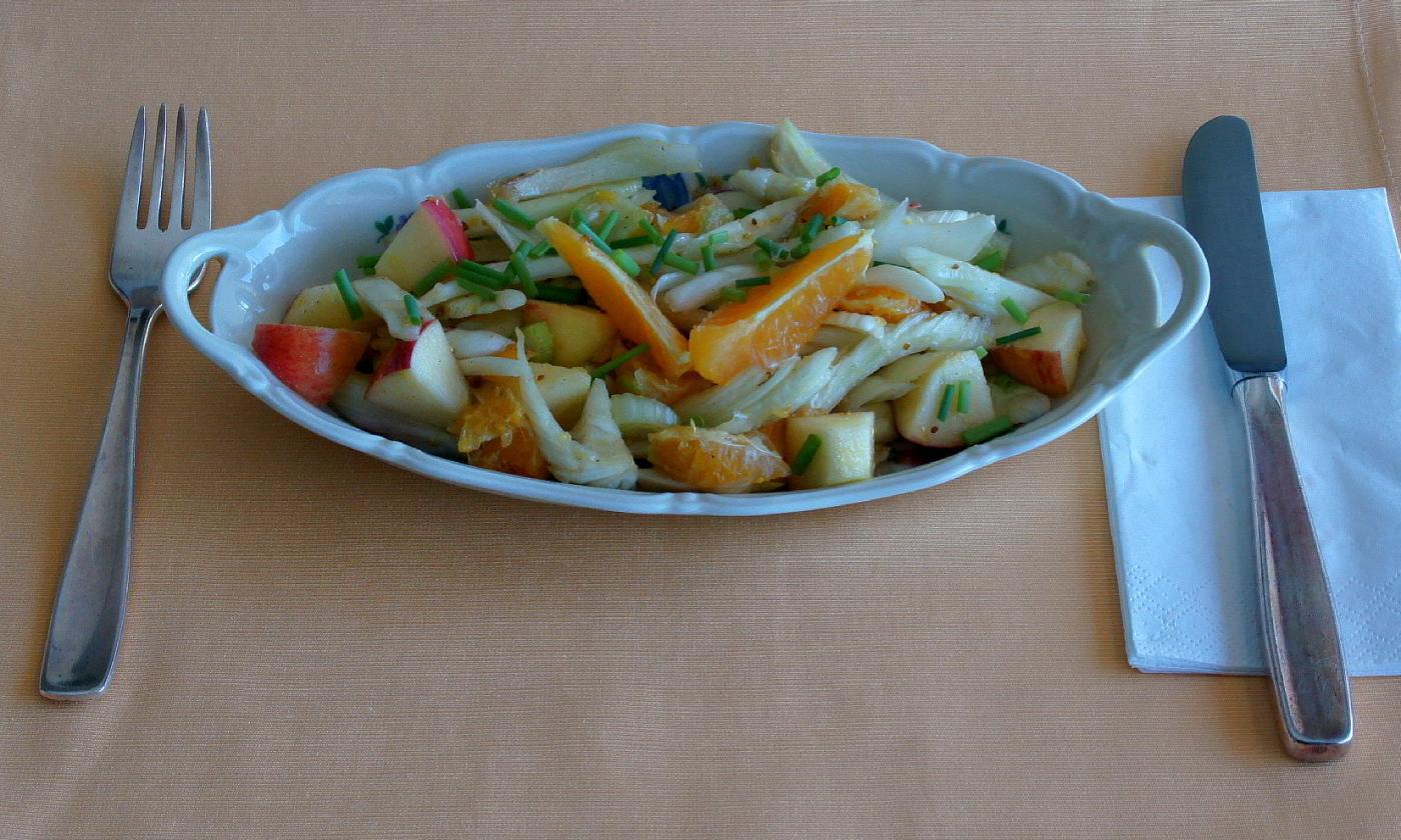 Готовый "Салат из фенхеля с яблоками и апельсинами" на тарелке.