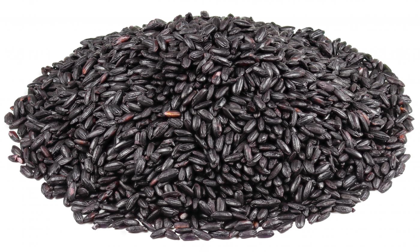 Riso nero, crudo, non trasformato, ammucchiato su uno sfondo bianco. Riso nero, crudo, non trasformato, ammucchiato su uno sfondo bianco.