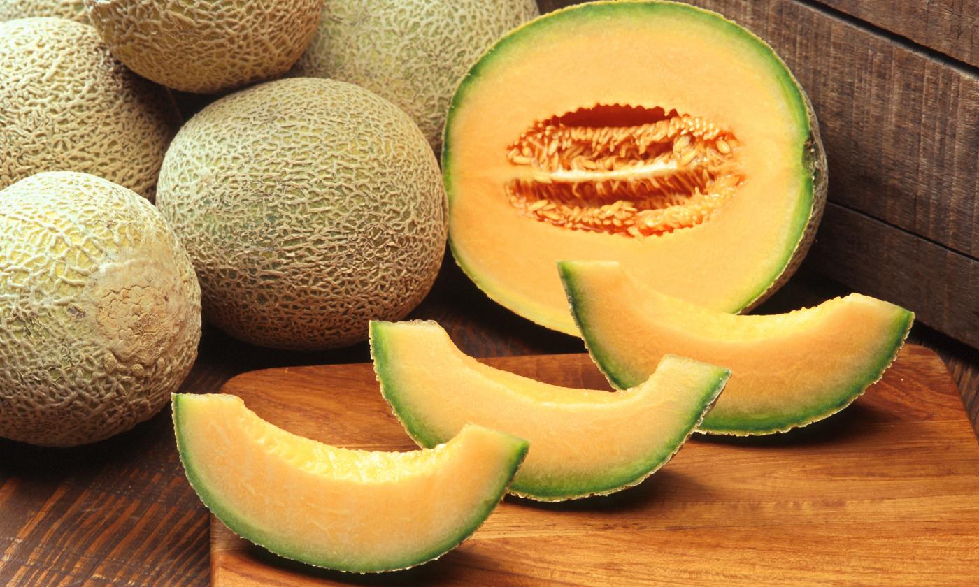 Слева целая дыня канталупа (Cucumis melo), справа разрезанная пополам, а спереди скибки дыни. Слева целая дыня канталупа (Cucumis melo), справа разрезанная пополам, а спереди скибки дыни.