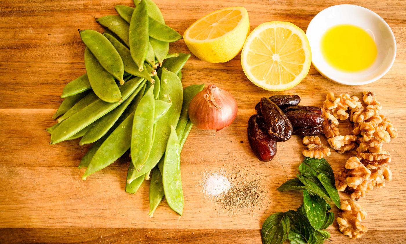 Preparing the ingredients for the "Raw Sugar Snap Pea Salad with Walnuts and Dates".