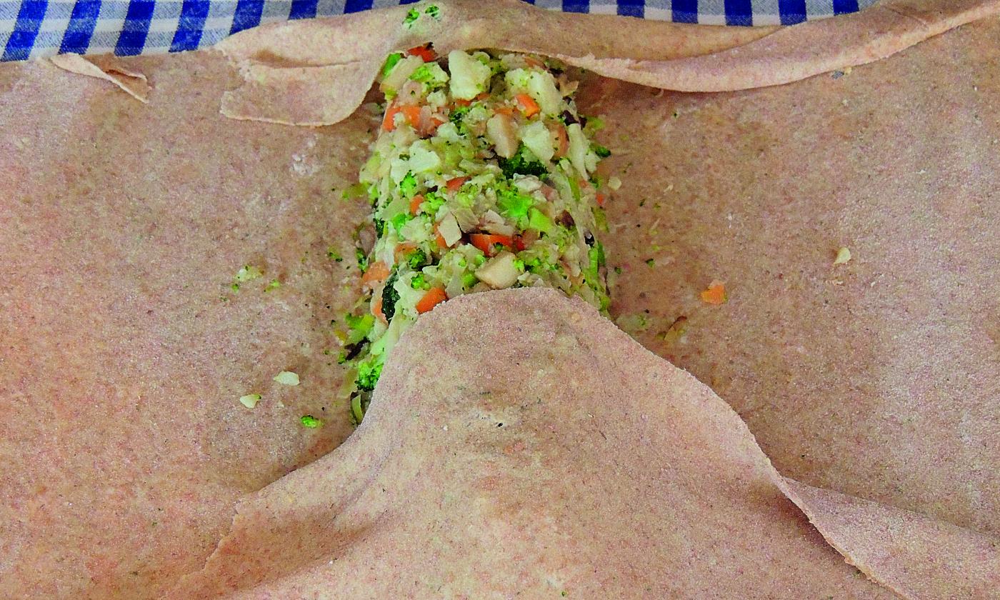 Rolling up the vegetables in the strudel dough for Vegetable Strudel with Frankfurt Green Sauce
