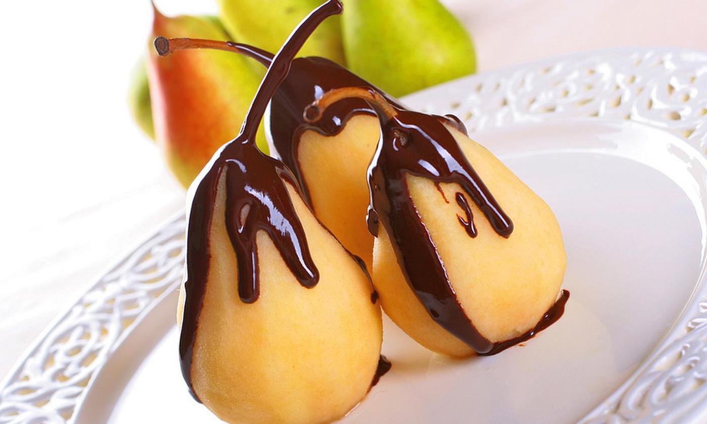 Dark couverture chocolate drizzled on poached (lightly cooked) pears. Dark couverture chocolate drizzled on poached (lightly cooked) pears.