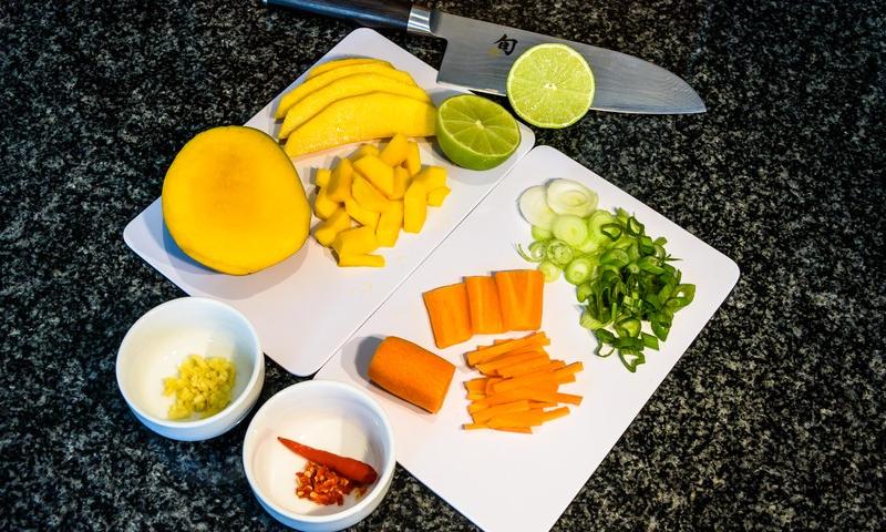 Ingredienti tagliati per preparare «Insalata asiatica di mango e spinaci».