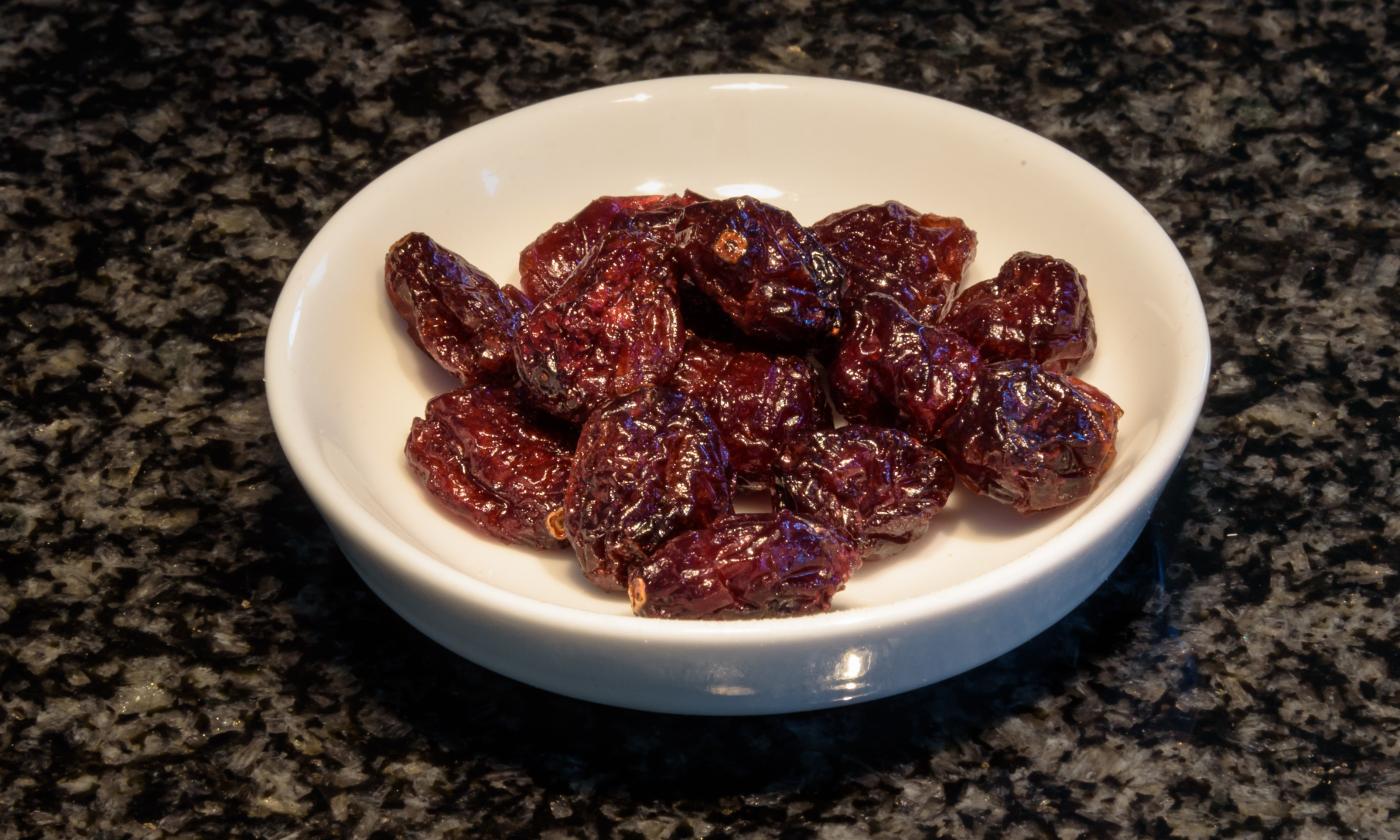 Bright peel on a dark background with sun-dried tomatoes (Solanum lycopersicum). Bright peel on a dark background with sun-dried tomatoes (Solanum lycopersicum).