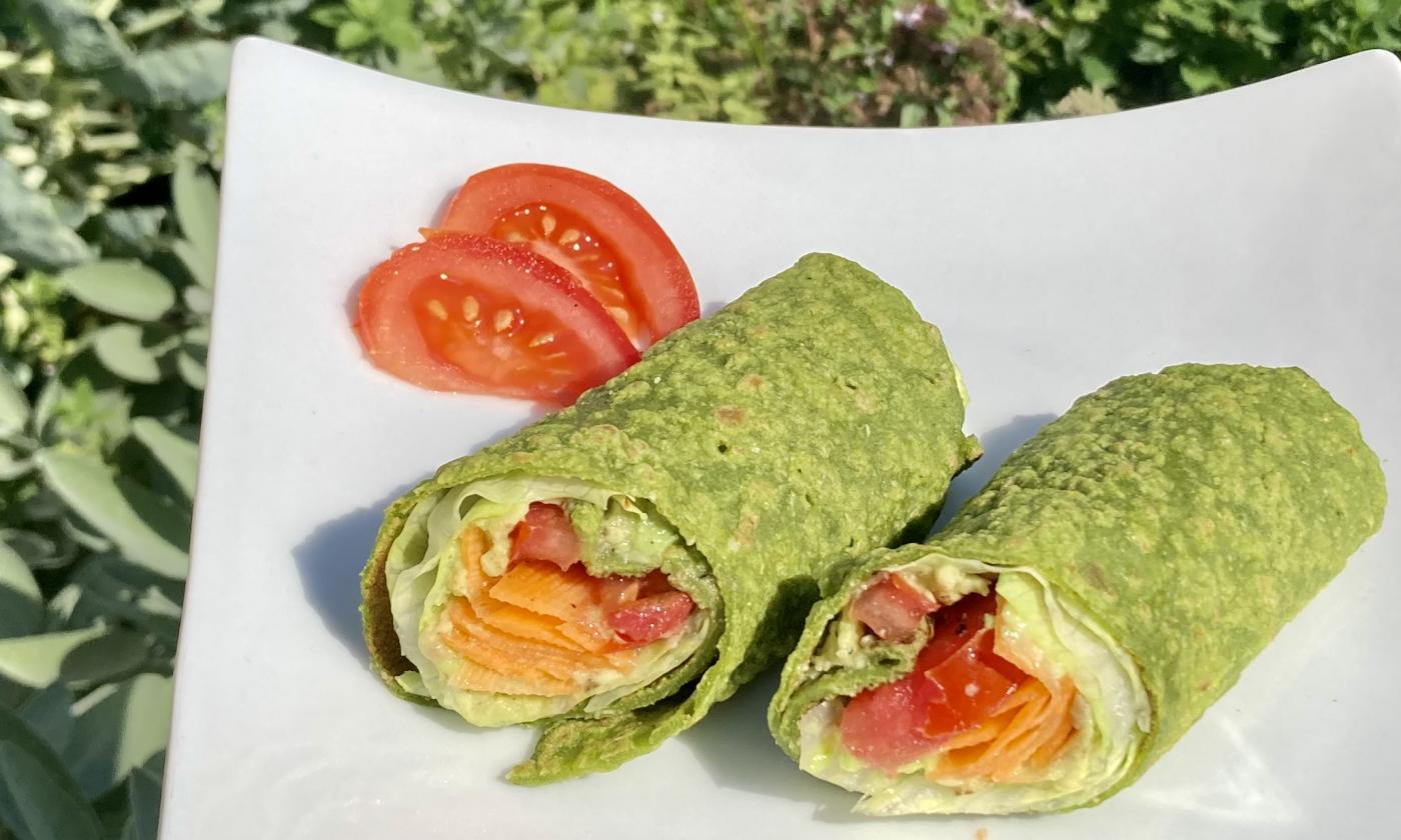 Recipe picture of the "Spinach and chickpea wraps with raw vegetable filling" on a white plate.