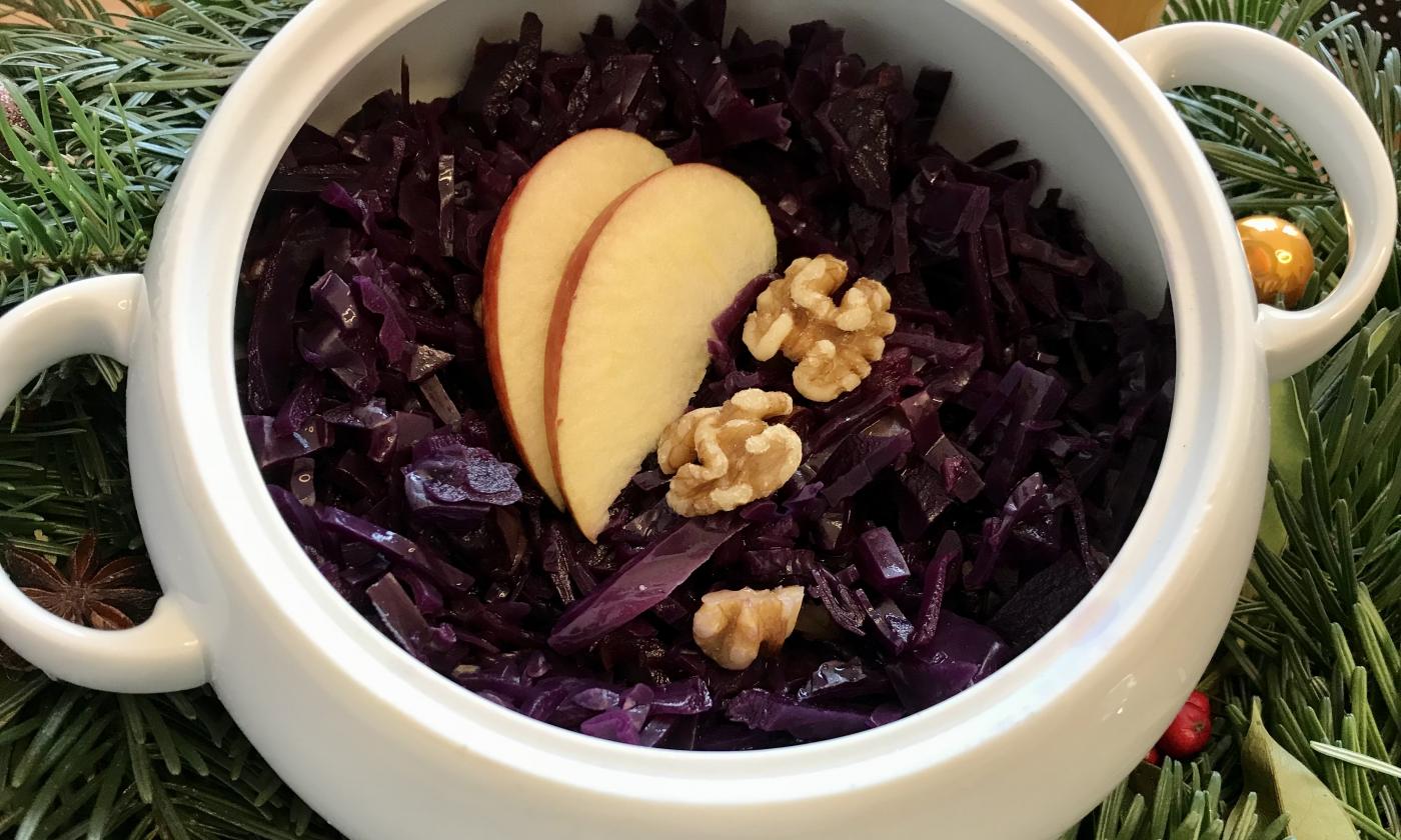 Ready prepared "Red cabbage with apple and walnut" in a white bowl.