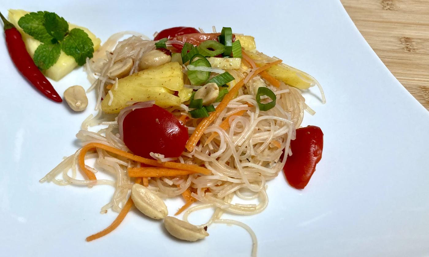 Rezeptbild vom fertigen "Asiatischen Glasnudelsalat mit gebratener Ananas" auf weissem Teller.