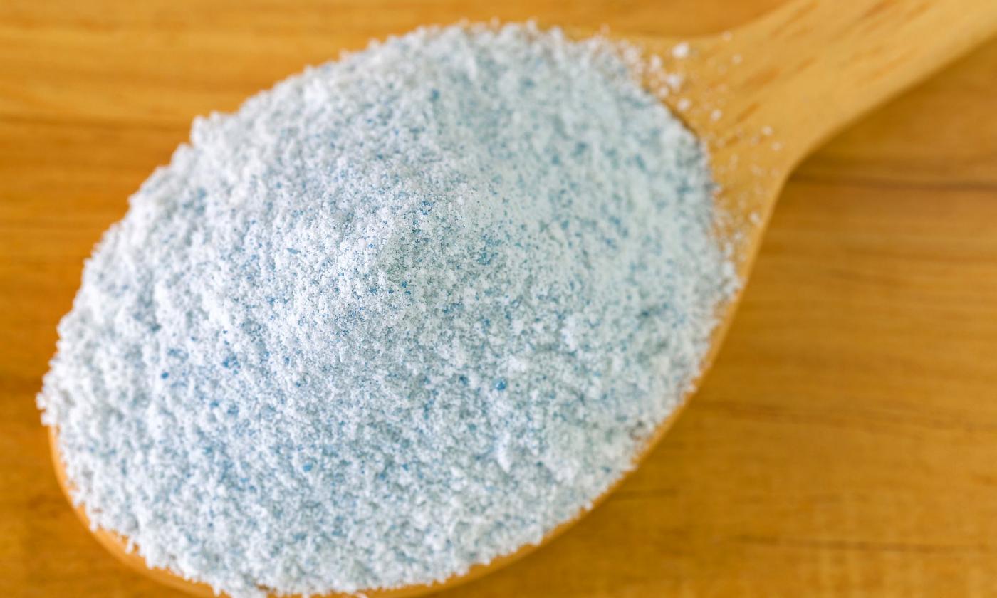 Holzlöffel gefüllt mit Joghurtferment in Pulverform für Erstellung eines Nussjoghurts.