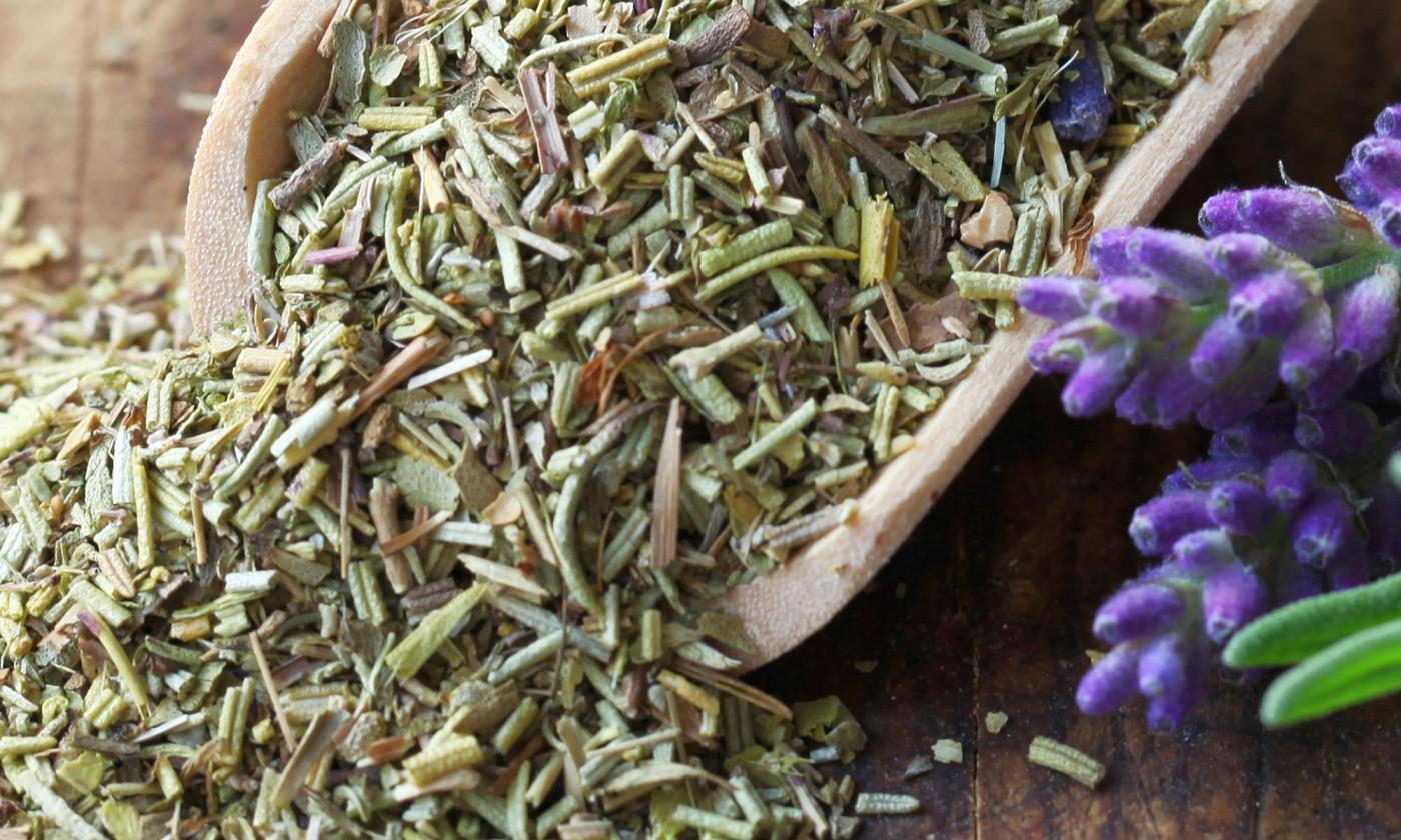 Hierbas de Provenza en un cucharón de madera con partes de plantas al lado, vista de primer plano. Hierbas de Provenza en un cucharón de madera con partes de plantas al lado, vista de primer plano.