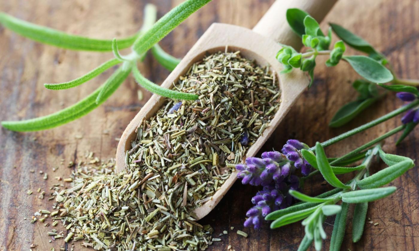Hierbas de Provenza en un cucharón de madera con partes de plantas al lado. Hierbas de Provenza en un cucharón de madera con partes de plantas al lado.