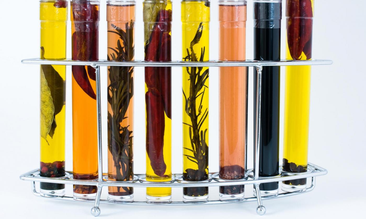 Kräuterweinessig: Verschiedene Kräuteressigsorten in speziellen Flaschen und Flaschenhalter. Kräuterweinessig: Verschiedene Kräuteressigsorten in speziellen Flaschen und Flaschenhalter.