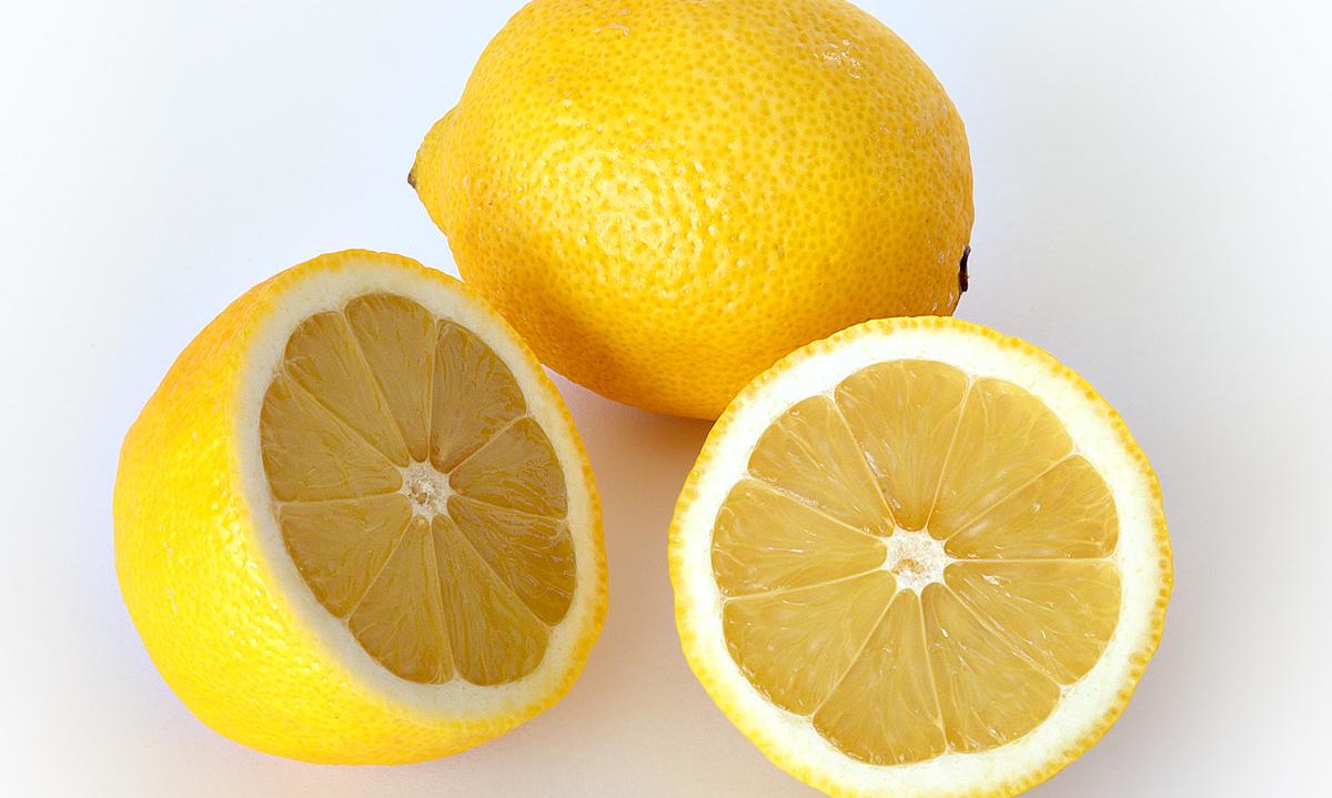 Imagen de limones maduros (Citrus limon): uno de los limones está cortado por la mitad y nos permite ver la estructura interior. Imagen de limones maduros (Citrus limon): uno de los limones está cortado por la mitad y nos permite ver la estructura interior.
