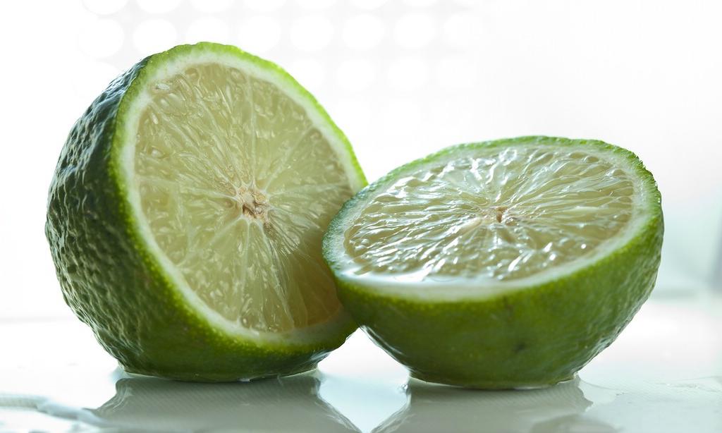 Фото разрезанного напополам лайма (Citrus aurantifolia), непосредственно перед переработкой в лаймовый сок. Фото разрезанного напополам лайма (Citrus aurantifolia), непосредственно перед переработкой в лаймовый сок.