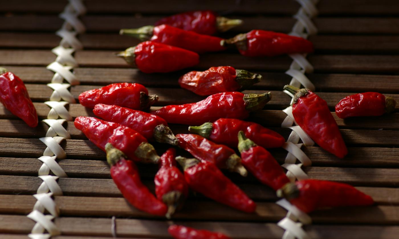 Перец чили красный, сырой - Capsicum annuum - на деревянной подстилке. Перец чили красный, сырой - Capsicum annuum - на деревянной подстилке.