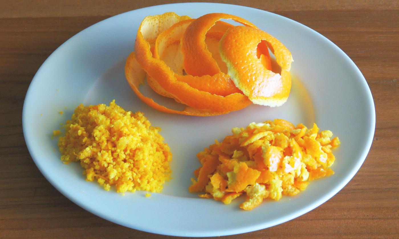 Orange peels on a plate. Different types of orange peels are shown here: intact (top), coarsely grated (right), and finely grated (left). Orange peels on a plate. Different types of orange peels are shown here: intact (top), coarsely grated (right), and finely grated (left).