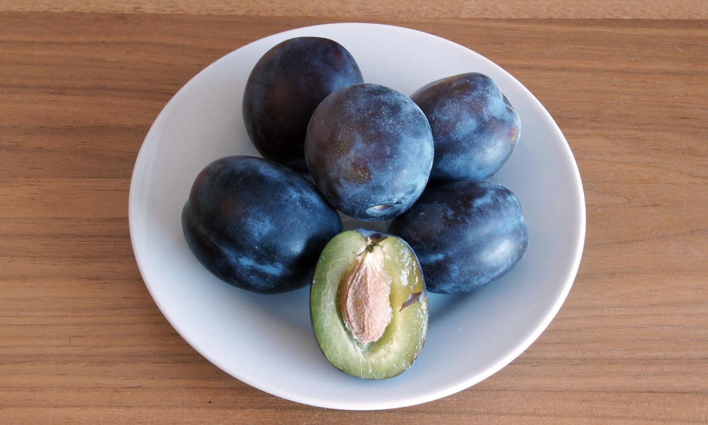 Ciruelas reales (pellizco) sobre un plato blanco pequeño. Ciruelas reales (pellizco) sobre un plato blanco pequeño.