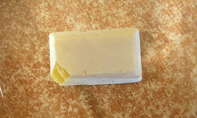 Weisser Phosphor unter Wasser mit gelber Schnittfläche.