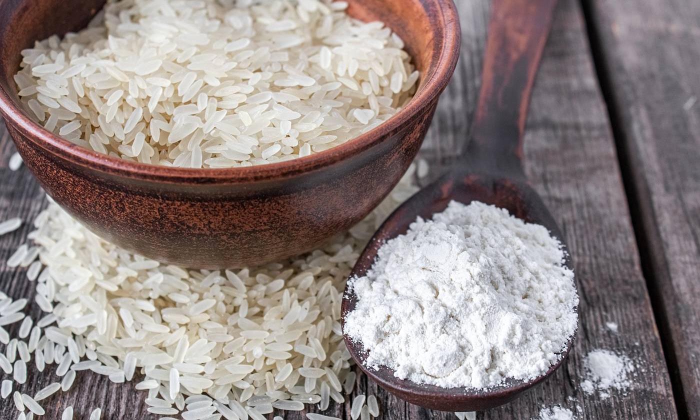 Reismehl, weiss (glutenfrei, roh, bio?), in Holzlöffel, links daneben weisse Reiskörner. Reismehl, weiss (glutenfrei, roh, bio?), in Holzlöffel, links daneben weisse Reiskörner.