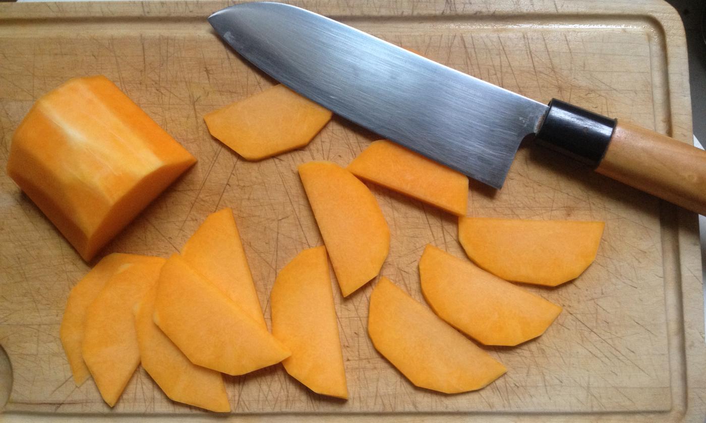 Rodajas de calabaza cortadas por la mitad tras pelar la calabaza para la lasaña con crema de anacardos y pesto de col rizada.