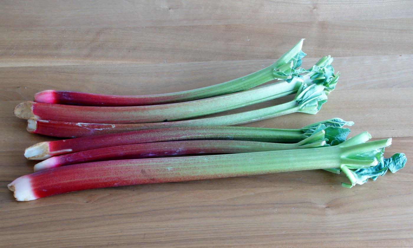 Ревень, сырой - Rheum rhabarbarum, 6 стеблей, лежащих на столе. Ревень, сырой - Rheum rhabarbarum, 6 стеблей, лежащих на столе.