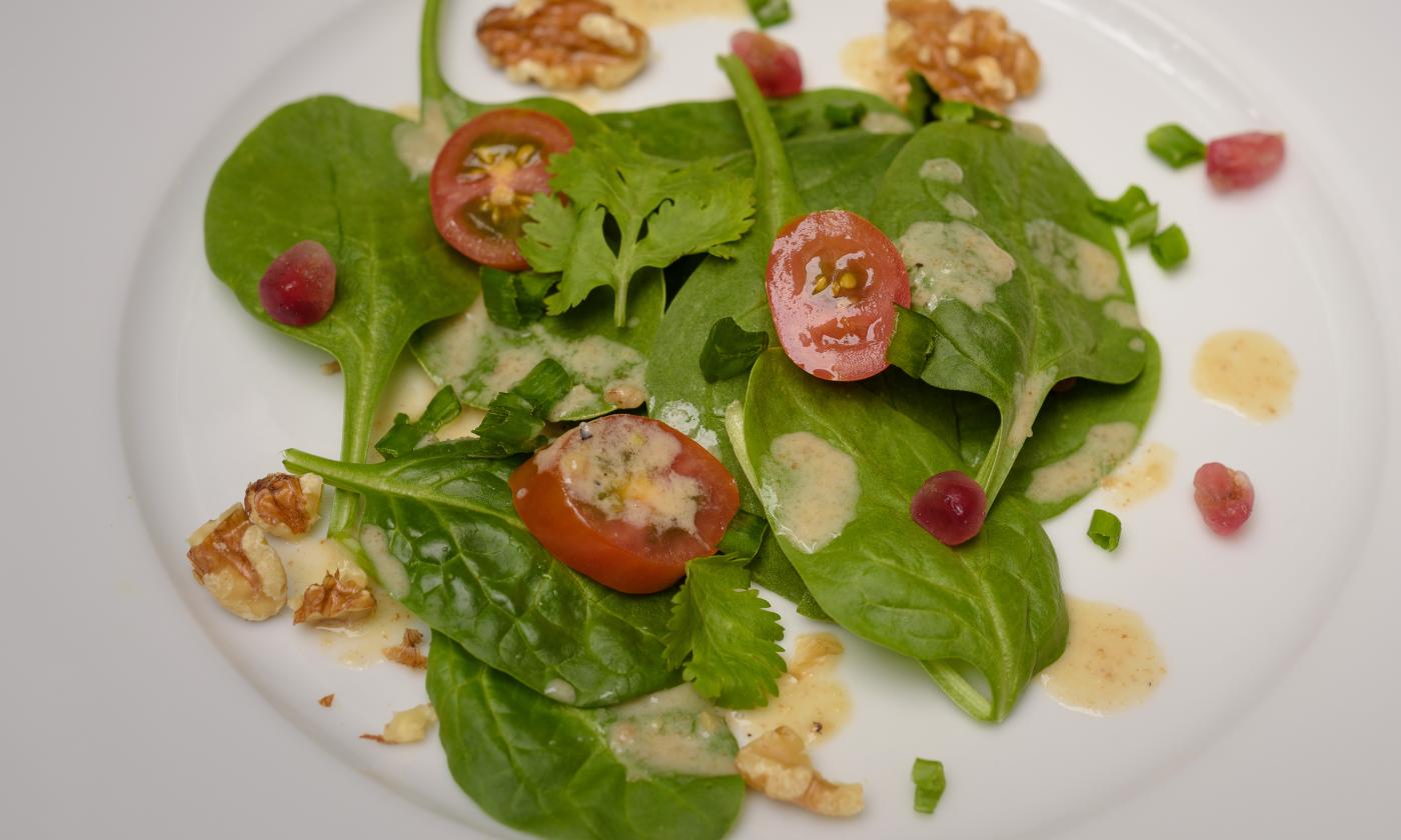 Salad dressed with "Oil-free salad dressing with walnuts and orange juice" on a plate.