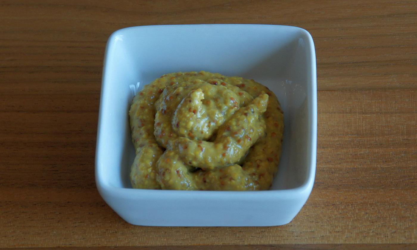 Собственная грубая горчичная паста в квадратной керамической чаше. Собственная грубая горчичная паста в квадратной керамической чаше.