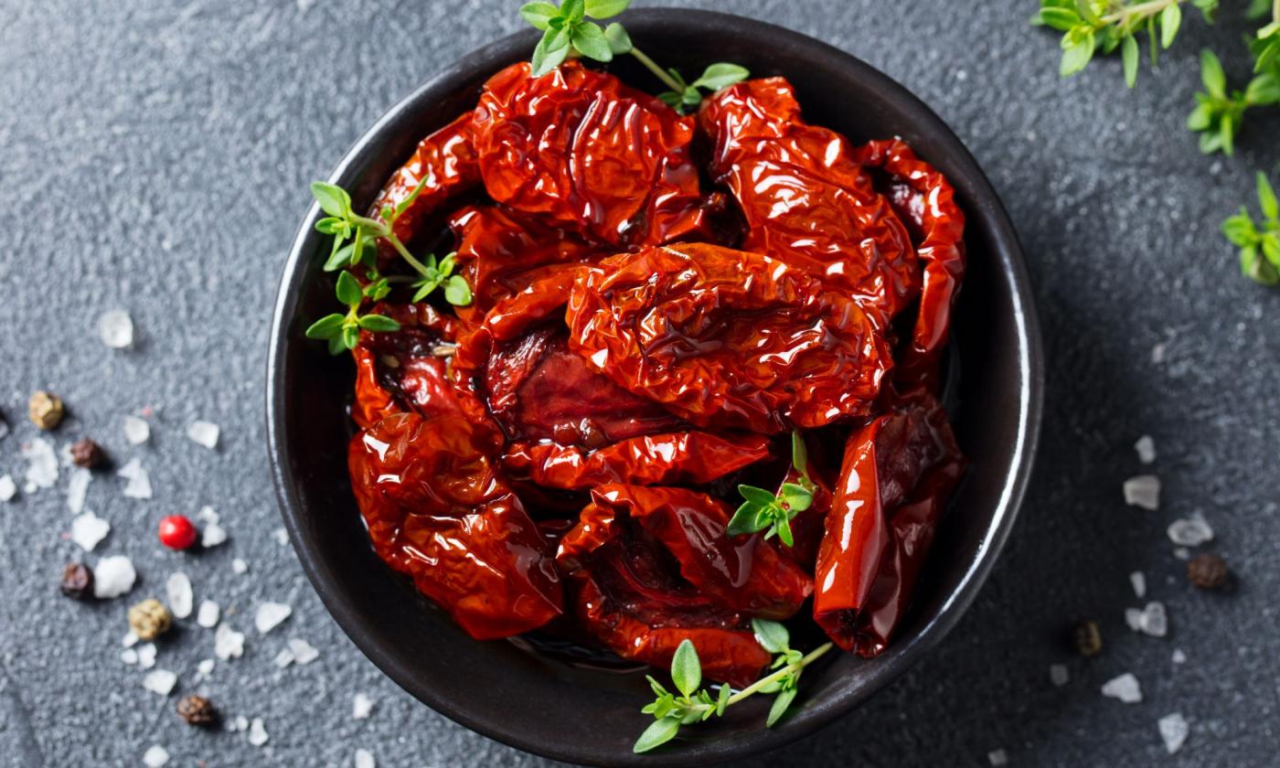 Mitades de tomate secado al sol con sal y especias con cáscara - Solanum lycopersicum. Mitades de tomate secado al sol con sal y especias con cáscara - Solanum lycopersicum.
