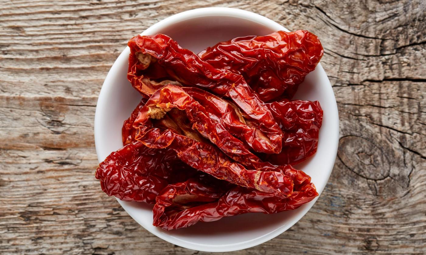 Sun-dried tomatoes without salt in a white porcelain bowl - Solanum lycopersicum. Sun-dried tomatoes without salt in a white porcelain bowl - Solanum lycopersicum.