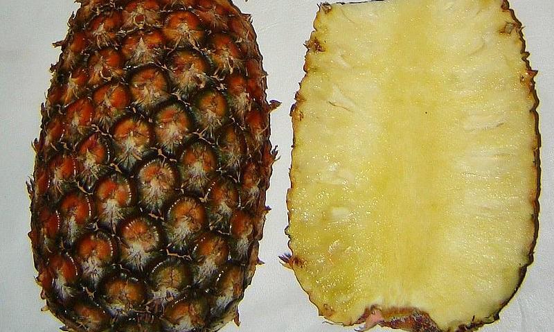 Piña entera y una rebanada longitudinalmente, una al lado de la otra. Piña entera y una rebanada longitudinalmente, una al lado de la otra.
