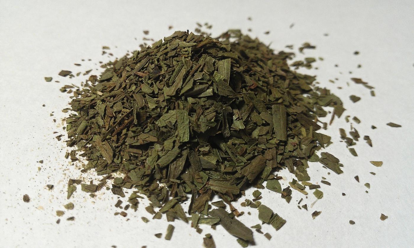 Сушеный эстрагон (Artemisia dracunculus) сложен на светлой поверхности. Сушеный эстрагон (Artemisia dracunculus) сложен на светлой поверхности.