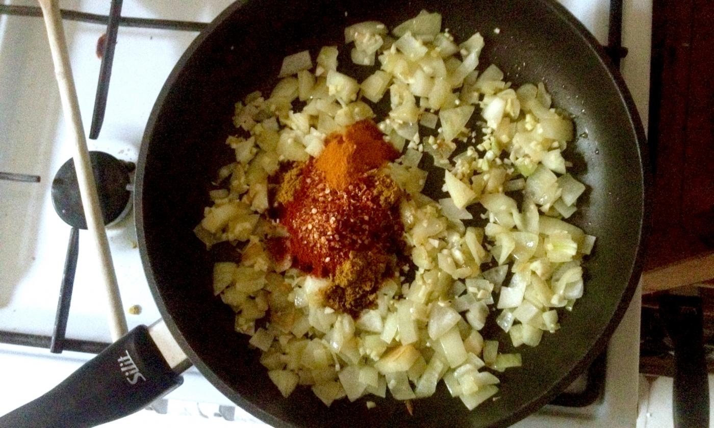 Zwiebeln, Knoblauch und Ingwer in der Pfanne mit den Gewürzen