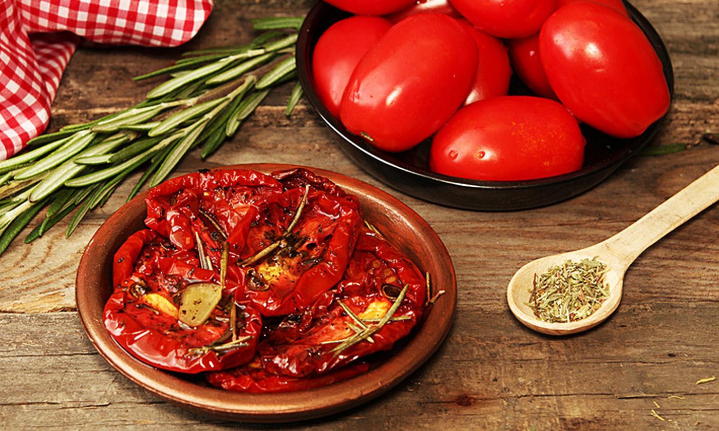 Tomato, dried or sun-dried in brown plate, tomatoes behind etc. - Solanum lycopersicum Tomato, dried or sun-dried in brown plate, tomatoes behind etc. - Solanum lycopersicum