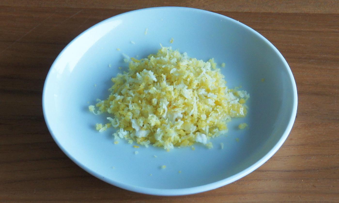 Fein geraspelte Zitronenschale in einer Schale: Zitronenschale unterstützt die Verdauung.