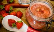 «Compota sin azúcar de fresas y ruibarbo con plátano» terminada sobre una mesa de madera marrón.