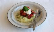 «Espaguetis de calabacín con salsas de tomate y anacardos» terminados y servidos en un plato.