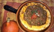 Imagen de «Calabaza Hokkaido con lentejas y tomates» preparada en una cazuela de barro.