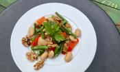 Imagen de «Ensalada de verduras sin aceite y con dos tipos de alubias» servido en un plato blanco.