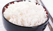 Cuenco negro de arroz glutinoso blanco cocido con dos palillos al lado.