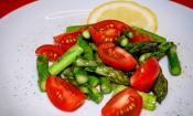 Imagen de «Ensalada templada de espárragos con tomates cherry» sobre un plato blanco.