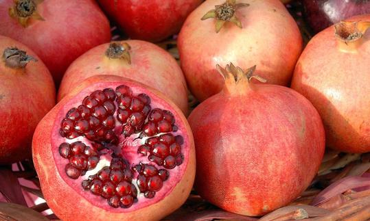 Frische Granatäpfel (Grenadine), dabei im Vordergrund eine aufgeschnittene Frucht. Frische Granatäpfel (Grenadine), dabei im Vordergrund eine aufgeschnittene Frucht.